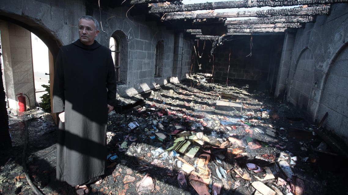 A priest inspects the damage at a room located on the complex of the Church of the Multiplication at Tabgha, on the shores on the Sea of Galilee in northern Israel, on June 18, 2015, in the aftermath of a suspected arson attack. The suspected attack totally destroyed an external atrium of the Christian shrine, which is believed by many Christians to be the place where Jesus fed the 5,000 in the miracle of the five loaves and two fish, with a church adviser pointing the finger at Jewish extremists. AFP PHOTO / MENAHEM KAHANA