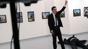 A man identified as Mevlut Mert Altintas shouts after shooting Andrei Karlov, the Russian Ambassador to Turkey, at a photo gallery in Ankara, Turkey, Monday, Dec. 19, 2016. 