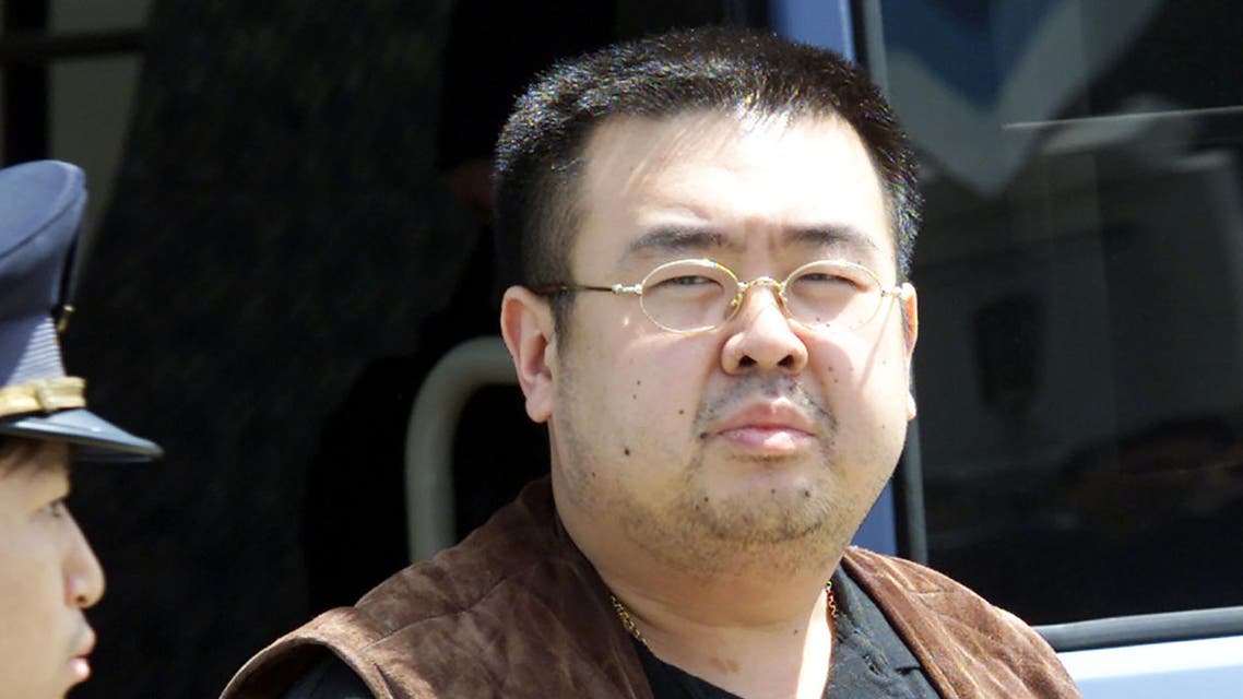 (FILES) This file photo taken on May 4, 2001 shows an immigration officer (L) escorting Kim Jong-Nam, son of North Korean leader Kim Jong-Il, getting off a bus to board an ANA905 (All Nippon Airways) airplane at Narita airport near Tokyo. Kim Jong-Nam, the half-brother of North Korean leader Kim Jong-Un has been assassinated in Malaysia, South Korea's Yonhap news agency said on February 14, 2017. AFP