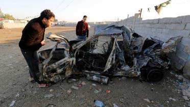 Men look at the wreckage of a burnt car after a suicide bomber detonated a pick-up truck on Wednesday in Sadr City. (File photo: Reuters)