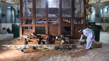 A Pakistani security official collects evidence a day after a bomb attack hit the 13th century Muslim Sufi shrine of Lal Shahbaz Qalandar. (AFP)