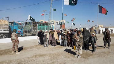 In this photograph taken on January 7, 2017, travellers are watched by Pakistan security personnel as they wait to cross the border between Pakistan and Afghanistan at Chaman. (AFP)