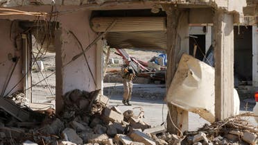 A security personnel walks past shops that were destroyed during clashes with ISIS militants (File Photo: Reuters/Muhammad Hamed)