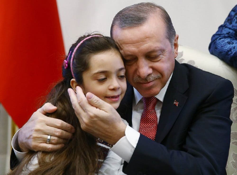 Turkey’s President Recep Tayyip Erdogan (right) posing as he holds in his arms the seven-year-old Bana al-Abed (left), who tweeted from Aleppo on the attacks, at the Presidential Complex in Ankara. (AFP)