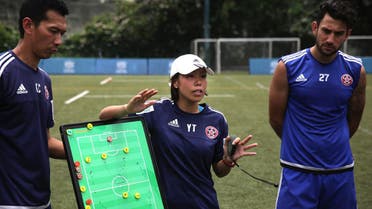 This picture taken on May 11, 2016 shows head coach of Eastern Football club Chan Yuen-ting (C) talking to her players during a team training session in Hong Kong. (AFP)