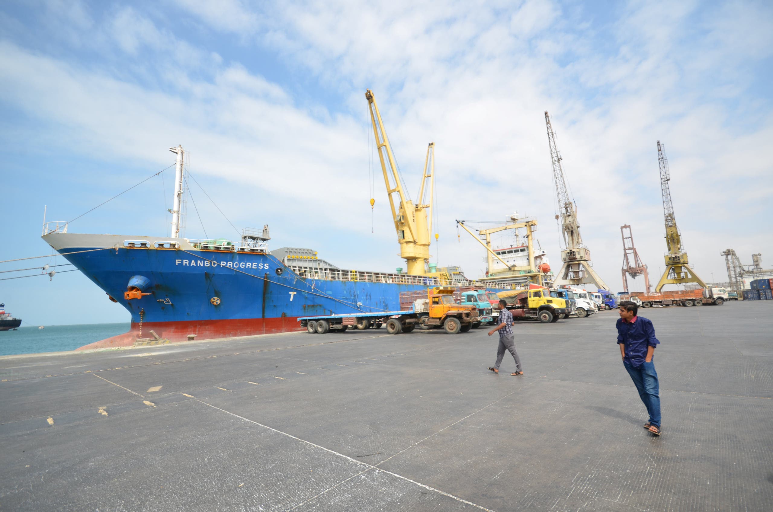 People walk past a ship ducked at the Red Sea port of Hodeidah, Yemen February 1, 2017