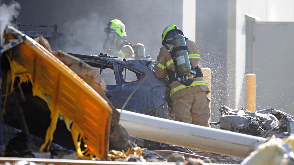 Firemen help put out the blaze resulting from the plane crash. (AP)