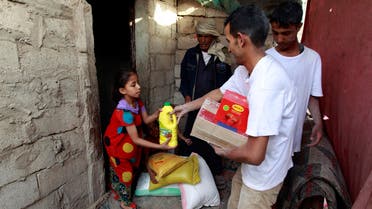 Yemeni volunteers of a local charity distribute food rations to families affected by the country's ongoing conflict on June 15, 2016 during the fasting month of Ramadan in an empoverished part of the capital Sanaa. (AFP)