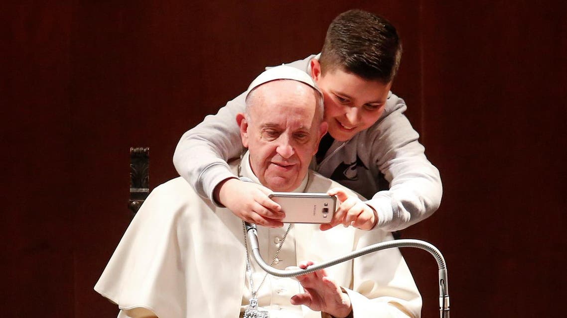 A boy takes selfies with Pope Francis during a visit at the parish of St. Mary Josefa of the Heart of Jesus in Rome February 19, 2017. Reuters