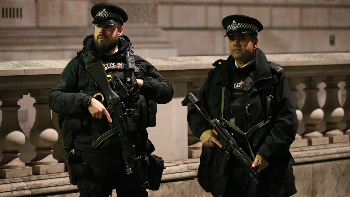 British police officers, some armed gather together ahead of the New Year's celebrations, in central London on December 31, 2016. London will have 3,000 officers on patrol with crowds flocking to line the banks of the Thames to watch the fireworks around the London Eye Ferris wheel.