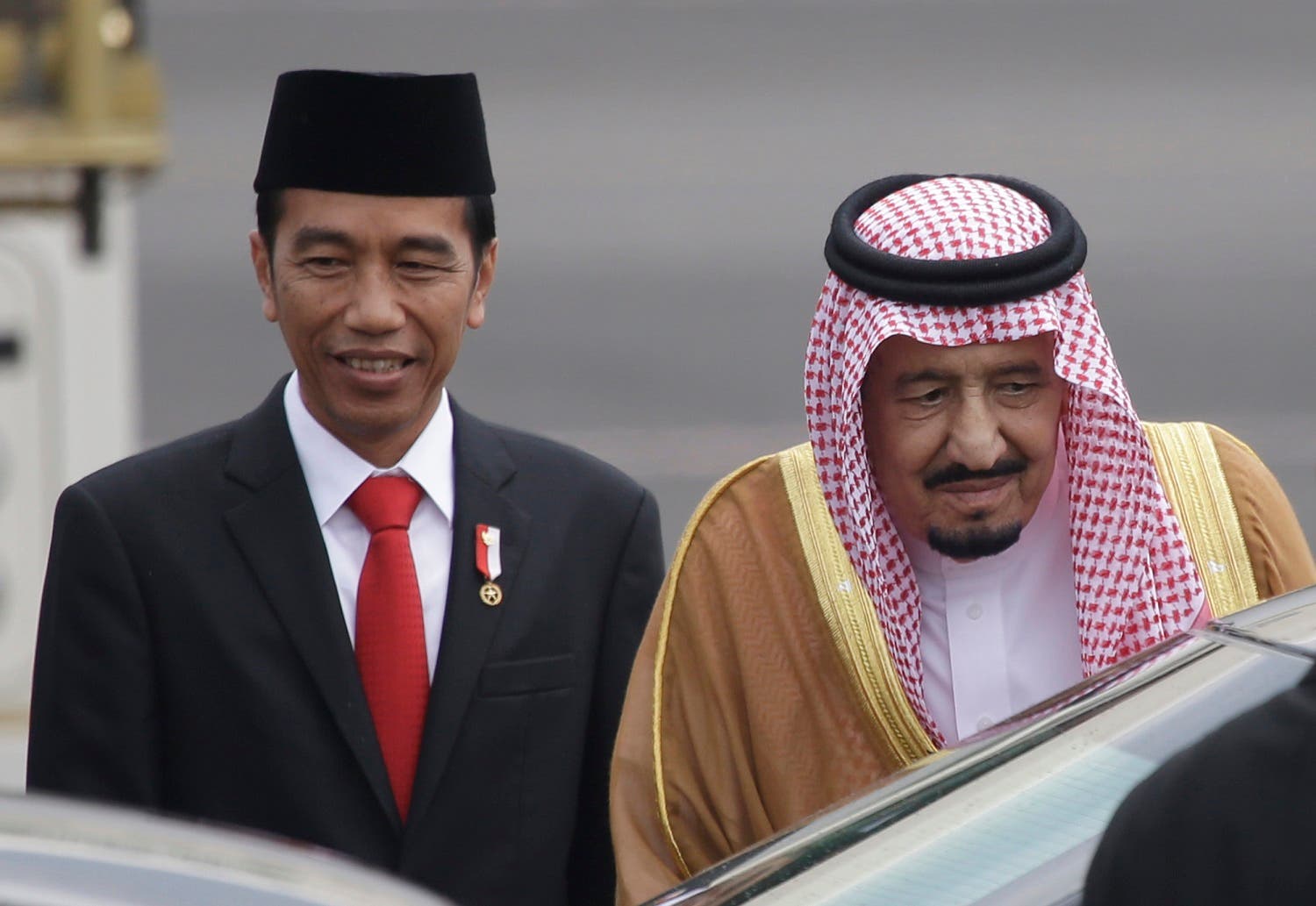 King Salman walks with Indonesian President Joko Widodo upon arrival at Halim Perdanakusuma Airport in Jakarta, Indonesia, Wednesday, March 1, 2017. (AP)