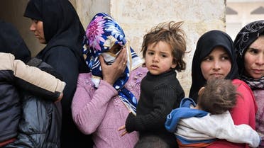 Displaced Syrian women queue up to receive medical aid and vaccines from Russian Army forces through paediatric field hospitals in the district of Jibreen, on the outskirts of the northern Syrian city of Aleppo on March 1, 2017. AFP