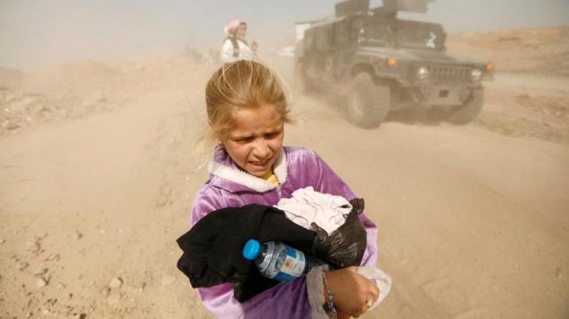 A displaced Iraqi girl reacts as she flees her home in Mamoun district as Iraqi forces battle with ISIS militants, in western Mosul. (Reuters)