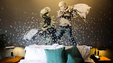 A Banksy wall painting showing Israeli border policeman and Palestinian in a pillow fight is seen in one of the rooms of the "The Walled Off Hotel" in the West Bank city of Bethlehem, Friday, March 3, 2017. (AP)