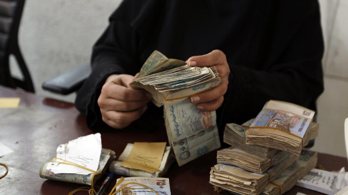 An employee counts stacks of Yemeni currency at the Central Bank of Yemen in the capital Sanaa on August 25, 2016.