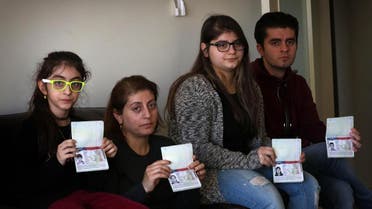 Fuad Sharif Suleman and his family show their US immigrant visas in Arbil, the capital of the Kurdish autonomous region in northern Iraq, on January 30, 2017 after returning to Iraq from Egypt, where they were prevented from boarding a plane to the US. (AFP)