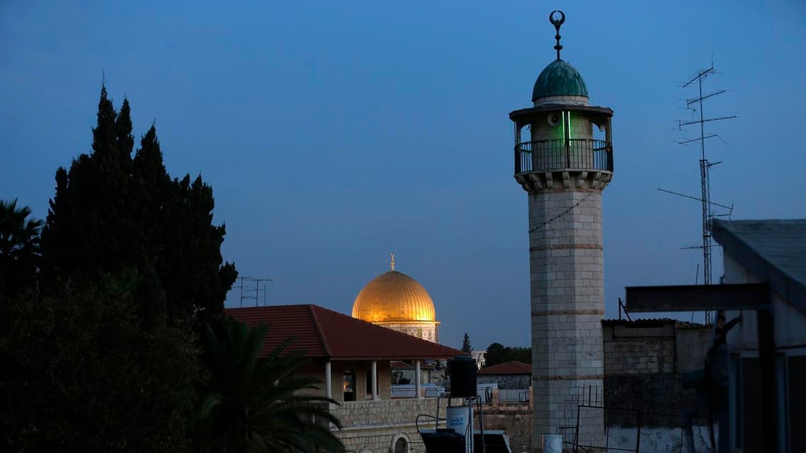 A picture taken on November 21, 2016 shows the minaret (R) of a mosque and the Dome of the Rock (background) in a Palestinian neighbourhood of east Jerusalem's Old City, on November 21, 2016. (AFP)