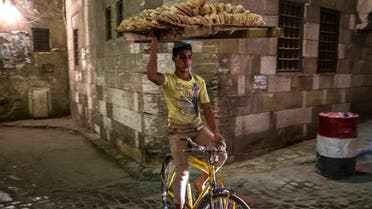 An Egyptian bread seller rides his bicycle in Cairo Khan el-Khalili district on July 8, 2014. (File photo: AFP)