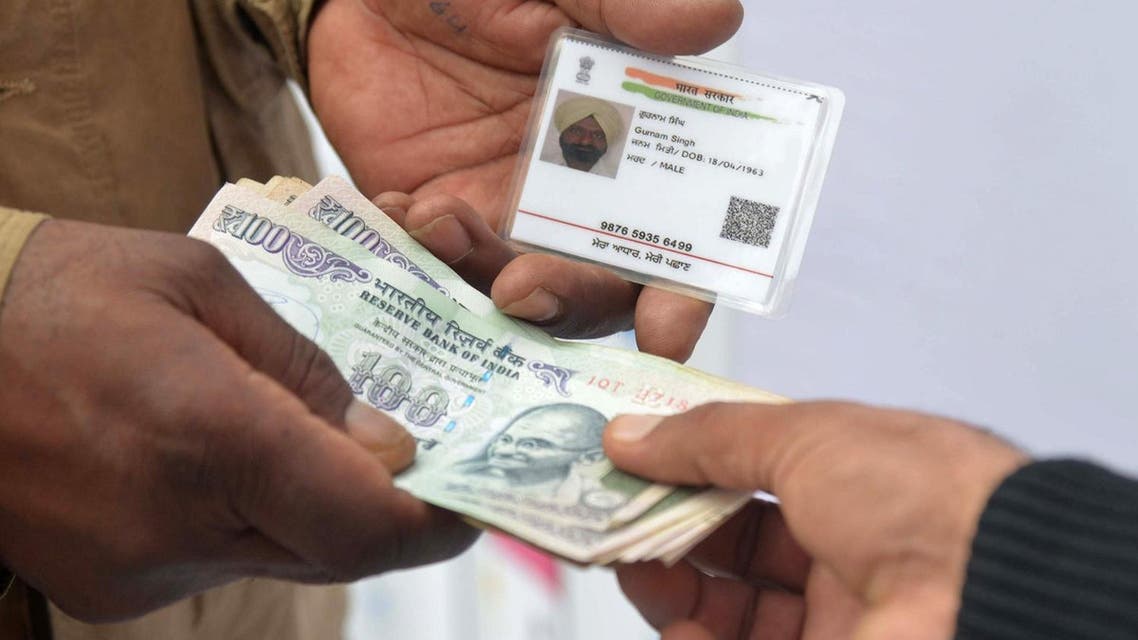 An Indian withdraws money from his bank account with an Aadhaar or Unique Identification (UID) card during a fair, held to promote digital payment, in Amritsar on January 6, 2017. (AFP)
