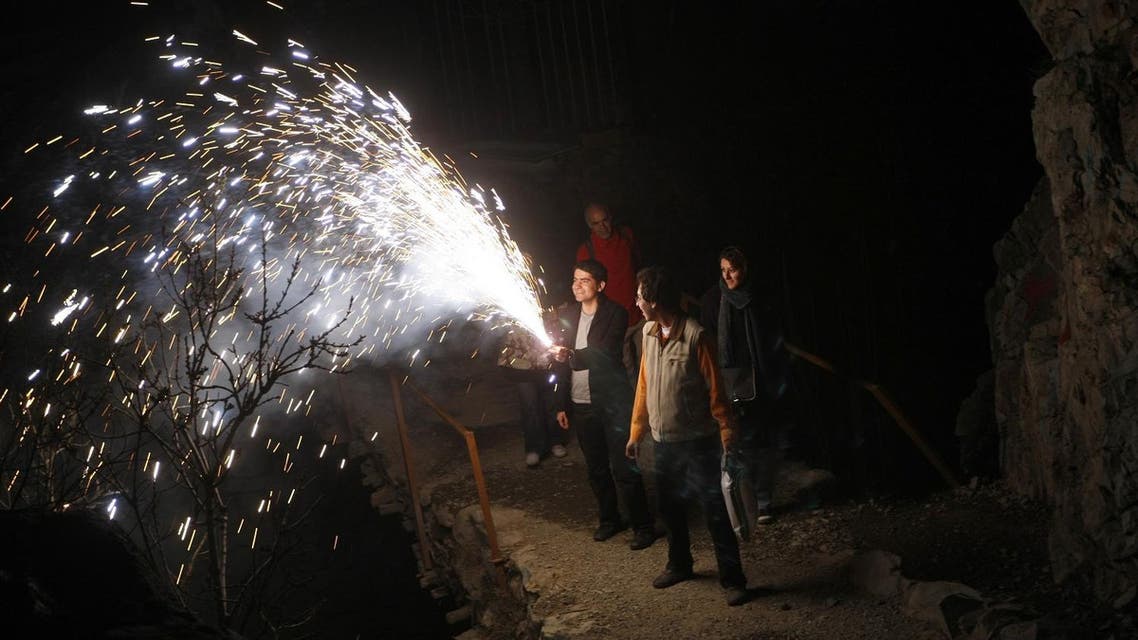 An Iranian man holds a firecracker during the "Chaharshanbeh Soori" or (Festival of Fire) in Darakeh mountain north of Tehran, late March 18, 2008. (AFP)