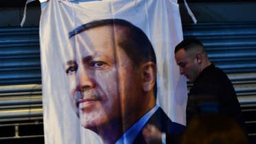 A man gestures in front of a flag bearing a portrait of Turkish President Recep Tayyip Erdogan as Turkish residents of the Netherlands gather for a protest outside Turkey's consulate in Rotterdam on March 11, 2017. Protests erupted in the Dutch port city of Rotterdam late on March 11 outside the Turkish consulate amid a row with Ankara after Dutch authorities banned the visits of Turkish ministers. About 1,000 people waving Turkish flags gathered on the street leading to the consulate, as tensions rocketed over rallies abroad to help Ankara gain backing for an April referendum vote. AFP