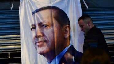 A man gestures in front of a flag bearing a portrait of Turkish President Recep Tayyip Erdogan as Turkish residents of the Netherlands gather for a protest outside Turkey's consulate in Rotterdam on March 11, 2017. (AFP)