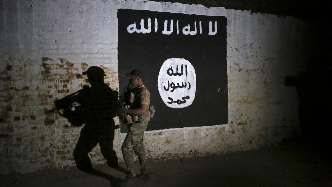 In this March 1, 2017 file photo, an Iraqi soldier inspects a recently-discovered train tunnel, adorned with an Islamic State group flag, that belonged to the former Baghdad to Mosul line, that was turned it to a training camp for IS fighters, in western Mosul, Iraq. (AP)