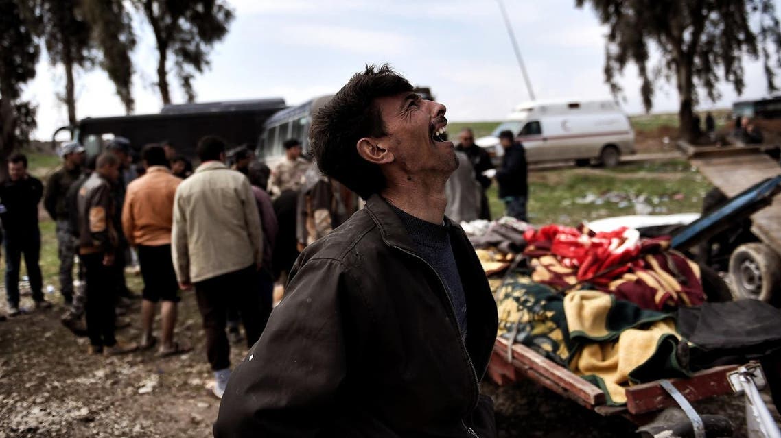 Relatives mourn as bodies of Iraqi residents of west Mosul killed in an airstrike targeting Islamic State (IS) group jihadists are placed and covered with blankets on carts on March 17, 2017. (AFP)