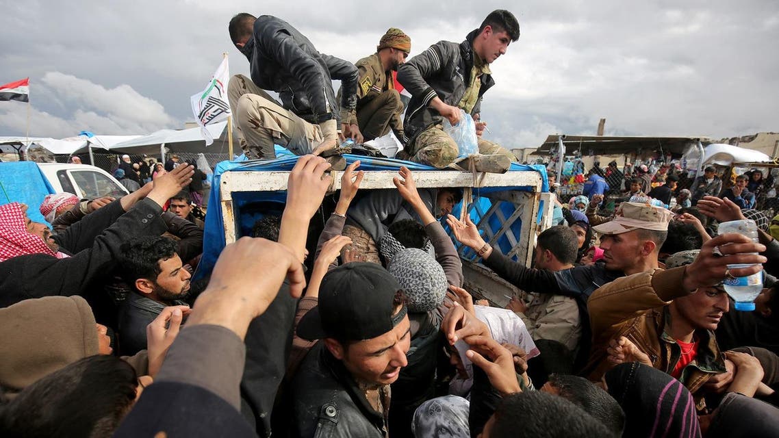 Iraqis, displaced from Mosul, receive aid rations at the Hammam al-Alil camp for the internally displaced, south of Mosul, on March 16, 2017. (AFP)