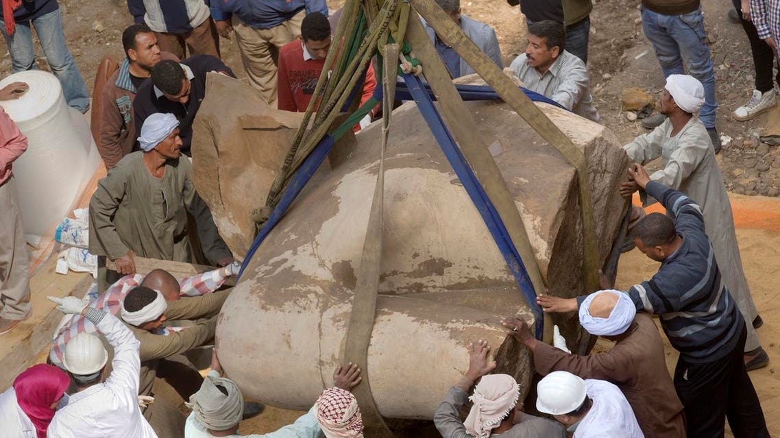 A massive statue, that may be of pharaoh Ramses II, one of the country's most famous ancient rulers, is surrounded by antiquities workers after it was pulled out of groundwater in a Cairo slum, Egypt, Monday, March 13, 2017. (AP)