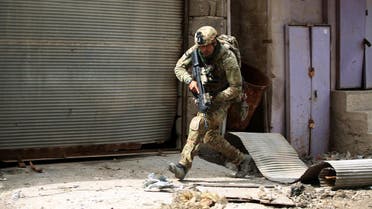 A member of the Iraqi forces, consisting of the Iraqi federal police and the elite Rapid Response Division, runs for cover as they advance in the Old City in western Mosul on March 19, 2017, during the offensive to retake the city from Islamic State (IS) group fighters. (AFP)