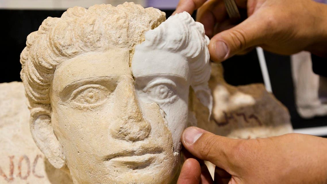 Restorer Antonio Iaccarino Idelson shows a computer-rendered, 3D print-generated replica of a missing part of a limestone male bust that was damaged during the Islamic State occupation of the Syrian city of Palmyra. (File photo: AP)
