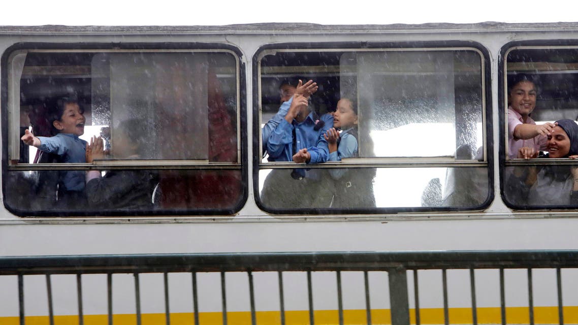 Egyptian children peer out of their school bus windows to feel rain drops in the upscale Zamalek district of Cairo, Egypt, Wednesday, Oct. 28, 2015