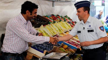 Belgian police officer Tarek Chatt talks to a man selling fruits and vegetables during a patrol at a market in, Belgium. (File Photo: Reuters)