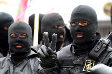 Masked members of Iran’s paramilitary Basij militia parade in front of the former US embassy in Tehran on November 25, 2011 to mark the national Basij week. (AFP)