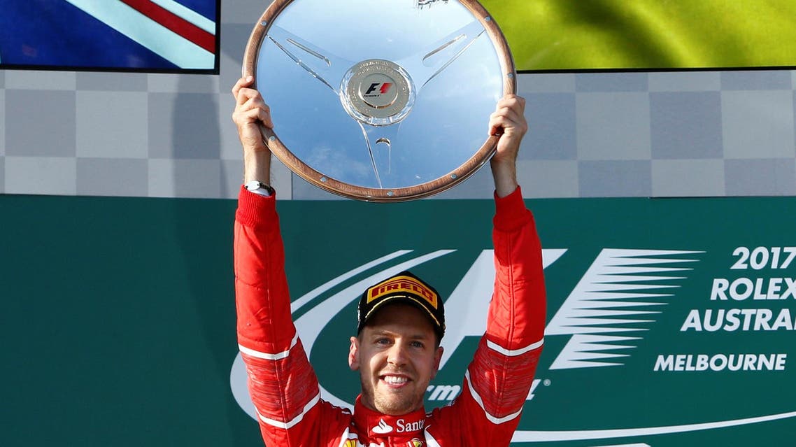 Formula One - F1 - Australian Grand Prix - Melbourne, Australia - 26/03/2017 - Ferrari driver Sebastian Vettel of Germany holds aloft the trophy as he celebrates winning the Australian Grand Prix. REUTERS/Brandon Malone