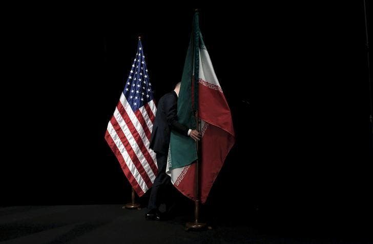 A staff member removes the Iranian flag from the stage during the Iran nuclear talks in Vienna, Austria July 14, 2015. (Reuters)