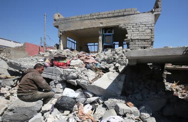 An Iraqi man sits amid the rubble of destroyed houses in the Mosul al-Jadida area on March 26, 2017. (AFP)