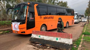 Buses drive past a Syrian army soldier to evacuate rebel fighters and their families from the besieged Waer district in the central Syrian city of Homs, after an agreement reached between rebels and Syria's army, Syria March 18, 2017. REUTERS/Omar Sanadiki