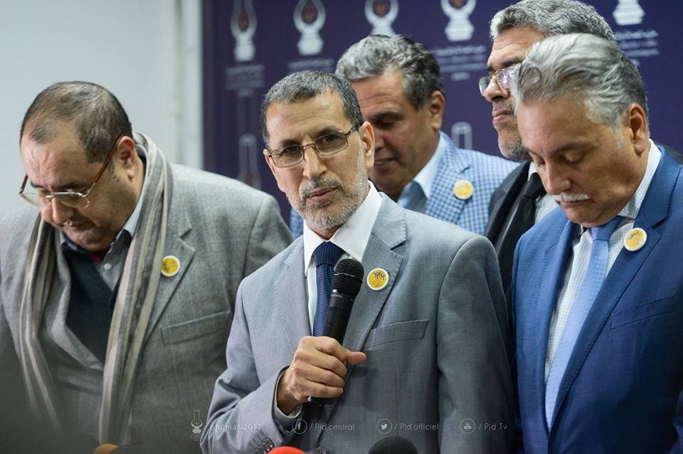 من إعلان التحالف الحكومي ويظهر إدريس لشكر مطأطأ الرأس على يمين سعد الدين العثماني