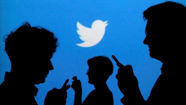  People holding mobile phones are silhouetted against a backdrop projected with the Twitter logo in this illustration picture taken September 27, 2013
