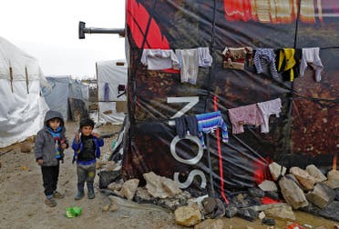 Syrian refugee children walk at an unofficial refugee camp in the village of Deir Zannoun in Lebanon's Bekaa valley on January 31, 2017.