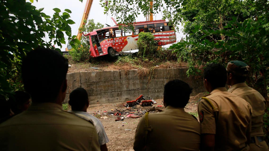 Policemen watch as a bus is pulled out from a ditch after it met with an accident on the outskirts of Mumbai, India, Sunday, June 5, 2016. The speeding bus struck two cars on a highway in a crash early Sunday that killed and injured passengers in western India, police said. (AP)