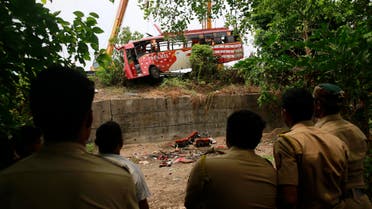 Policemen watch as a bus is pulled out from a ditch after it met with an accident on the outskirts of Mumbai, India, Sunday, June 5, 2016. The speeding bus struck two cars on a highway in a crash early Sunday that killed and injured passengers in western India, police said. (AP)