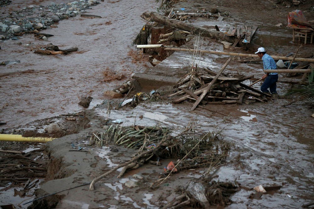 A man searches for his belongings after heavy rains caused several rivers to overflow, pushing sediment and rocks into buildings and roads in Mocoa, Colombia, April 1, 2017. (Reuters)