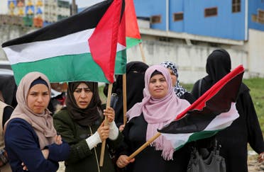 Women wave flags during a rally marking the 41st anniversary of Land Day, on the Palestinian side of the Beit Hanoun border crossing between Israel and the Gaza Strip on March 30, 2017. (AP)