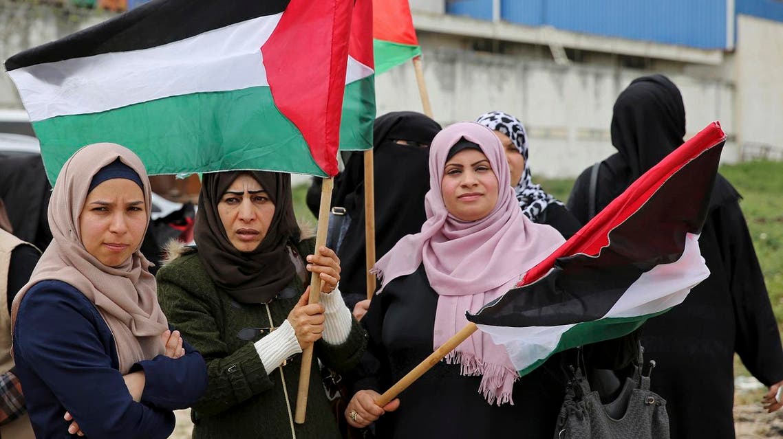 Women wave flags during a rally marking the 41st anniversary of Land Day, on the Palestinian side of the Beit Hanoun border crossing between Israel and the Gaza Strip on March 30, 2017. (AP)