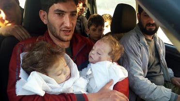 Abdul-Hamid Alyousef holds his twin babies who were killed during a suspected chemical weapons attack, in Khan Sheikhoun in Idlib. (AP)