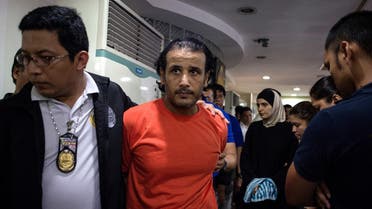 Kuwaiti national Husayn Al-Dhafiri (2nd L) and Syrian national Rahaf Zina (2nd R) are escorted by National Bureau of Investigation (NBI) personel after a press conference in Manila. (AFP)