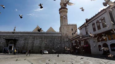 Pigeons fly in front of the Umayad Mosque, also known as the Grand Mosque of Damascus, on April 7, 2017. (AFP)